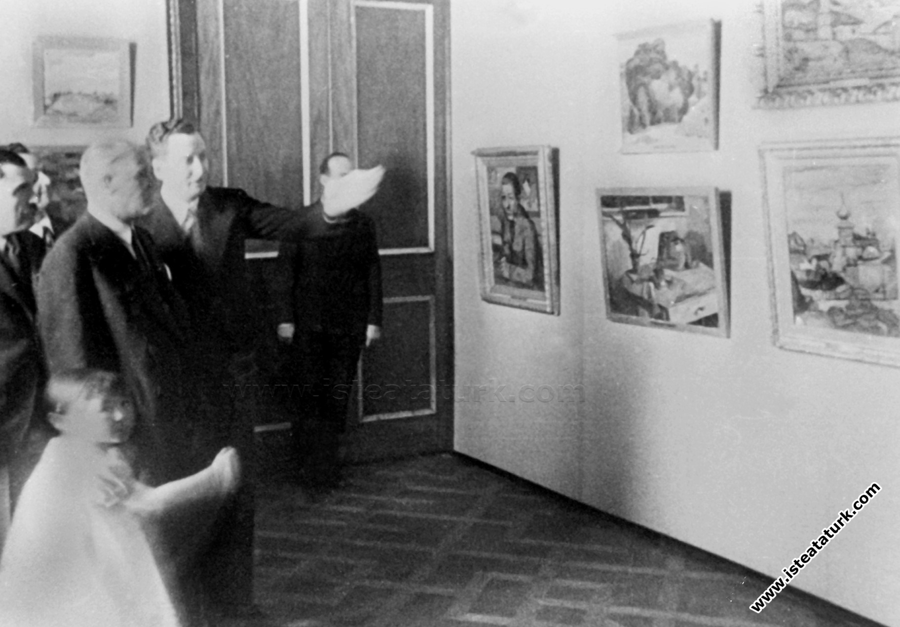Mustafa Kemal Atatürk Dolmabahçe Sarayı'nın bir bölümünde açılan İlk Devlet Resim ve Heykel Müzesi'ni gezerken,  müzenin ilk müdürü Halil Dikmen'den bilgi alıyor. (20.09.1937)